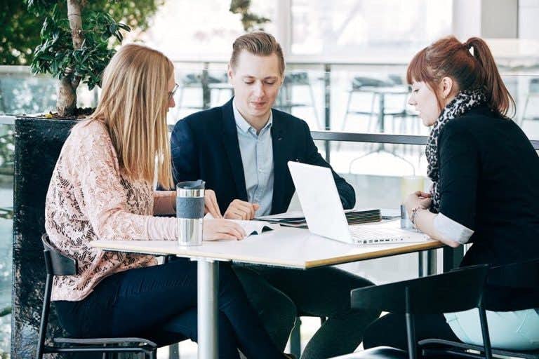 Professionals conduct a meeting in a cafeteria
